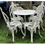 A weathered cream painted cast aluminium garden terrace table with decorative circular pierced