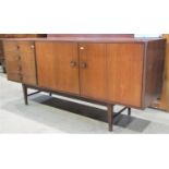 A teak wood sideboard fitted with four frieze drawers and two cupboard doors, raised on an open