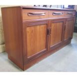 A G-Plan teak wood sideboard enclosed by three frieze drawers and four panelled doors, raised on a