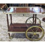 A mid-20th century two tier tea trolley with brass wagon wheel supports