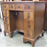 A Georgian style kneehole writing desk, the central kneehole surrounded by eight drawers with