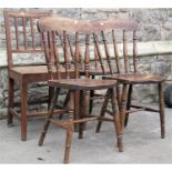 A set of three Windsor stained elm and beechwood kitchen chairs with turned spindle backs,