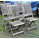 A set of four Winchester Collection weathered teak folding garden chairs with slatted seats and