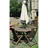 A weathered hardwood garden table, with hexagonal slatted top raised on folding X framed supports,