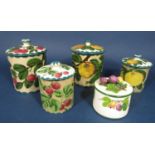 A collection of Wemyss wares comprising two cylindrical jars and covers, 16cm tall approx, one