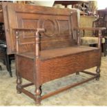 1920s medium oak monks type bench, with hinged box seat and sliding rectangular moulded panel top,
