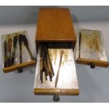 A small pine tower of three drawers each holding a selection of oiling or calligraphy brushes 18cm