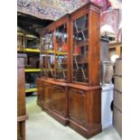 A Georgian style yew wood veneer breakfront four door bookcase, the lower section enclosed by four