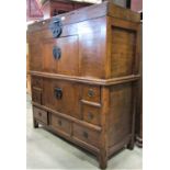 A Korean elm cabinet with rising lid over two further sections enclosed by an arrangement of