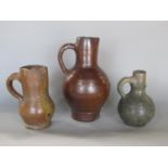 Three small glazed stoneware bellarmine type jugs with moulded loop handles, the largest 20 cm