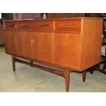 A G-Plan teak wood sideboard enclosed by four doors and four drawers on an open framework, 153cm