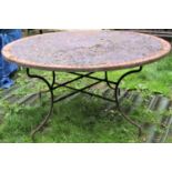 A weathered Moroccan garden table, the circular mosaic and wriggle pattern entwined lattice top with