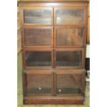 An oak four sectional bookcase enclosed by hinged glazed panelled doors, 90cm wide