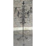 An iron work floorstanding three branch candle stand with leaf/petal sconces, scrolled detail and