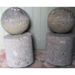 A pair of weathered granite spheres raised/set on cylindrical supports and possibly associated loose