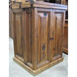 A pine drinks cabinet enclosed by two doors, the interior partially fitted with a wine rack,