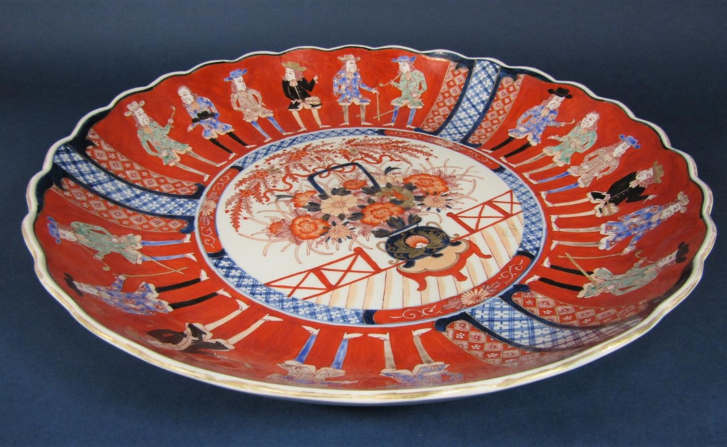 A large oriental charger in the 18th century imari style with flower vase detail to the centre