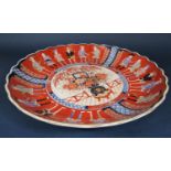A large oriental charger in the 18th century imari style with flower vase detail to the centre