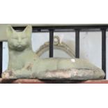 A green painted and weathered composite garden ornament in the form of reclining cat