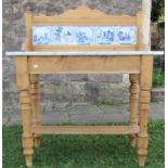 A Victorian stripped and waxed pine wash stand with marble top, enclosing a series of delft