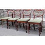 A set of four Victorian walnut dining chairs with kidney shaped backs over drop-in upholstered seats