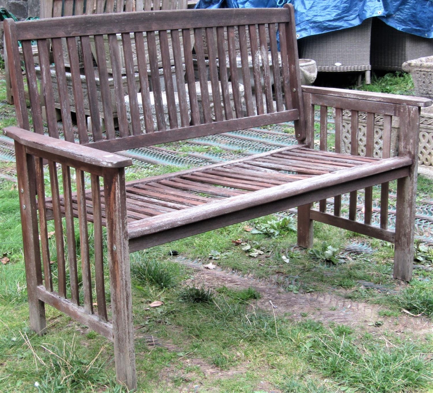 A contemporary weathered hardwood two seat garden bench with slatted seat, back and arms, (af) 126cm