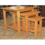 A nest of three graduated contemporary light oak occasional tables, with rectangular tops raised