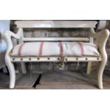 A 19th century rustic bench with crook arms, upholstered seat and raised on shaped supports with