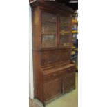 A late Victorian walnut two sectional secretaire bookcase cupboard, enclosed by an arrangement of