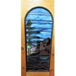 Arched stained glass panel depicting a tree in a rural landscape, with pine surround, the panel 71 x