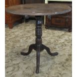 A 19th century oak country made occasional table the circular top raised on a ring turned pillar and