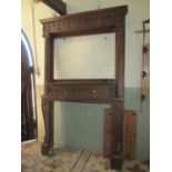 A large late Victorian/Edwardian period oak fire surround/chimney piece, the raised back enclosing a