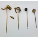 Four yellow metal stick pins to include a 9ct riding crop example, 6.7g total (4)