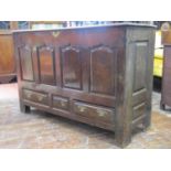 A substantial 18th century oak mule chest, with rising lid, the front elevation enclosed by four