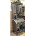 A Victorian oak ladies writing bureau with extensive carved detail, the base fitted with an