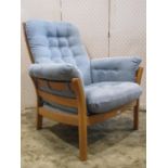 A contemporary Ercol Saville upholstered armchair with polished frame and pale blue button suede