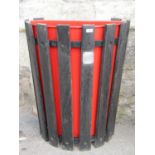 A reclaimed wall/fence mounted demi-lune litter bin with open slatted framework by Lister,