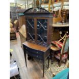 An Edwardian mahogany cabinet, the lower section enclosed by two serpentine drawer with blind fret