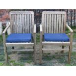 A pair of Made On Earth weathered hardwood garden open armchairs with slatted seats and backs