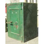 An old cast iron safe enclosed by a single door with T shaped handle, lock and key, the interior