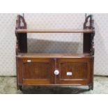 A Victorian mahogany wall shelf partially enclosed by two panelled doors with pierced sides,