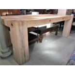 A good quality pale oak kitchen dining table raised on four heavy square cut supports (each