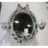Late 19th century German porcelain mirror, oval, surmounted by two cherubs supporting three candle