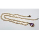 Yellow metal pear cut amethyst pendant hung on an associated baroque pearl necklace with silver gilt