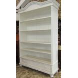 A freestanding bookcase enclosing four adjustable shelves, over a single frieze drawer with carved