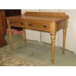 A waxed pine side table fitted with two frieze drawers on turned supports, 115cm wide