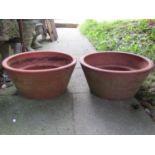 A pair of weathered terracotta garden planters of shallow circular and tapered form, 58 cm in