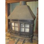 A Hunter cast iron wood burning stove enclosed by a pair of partially glazed panelled doors