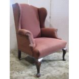 Georgian style wing chair with scrolled arms raised on cabriole