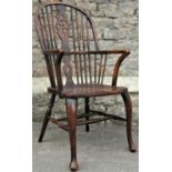 A Georgian style Windsor wheel back elbow chair, principally in elm and ash woods, raised on